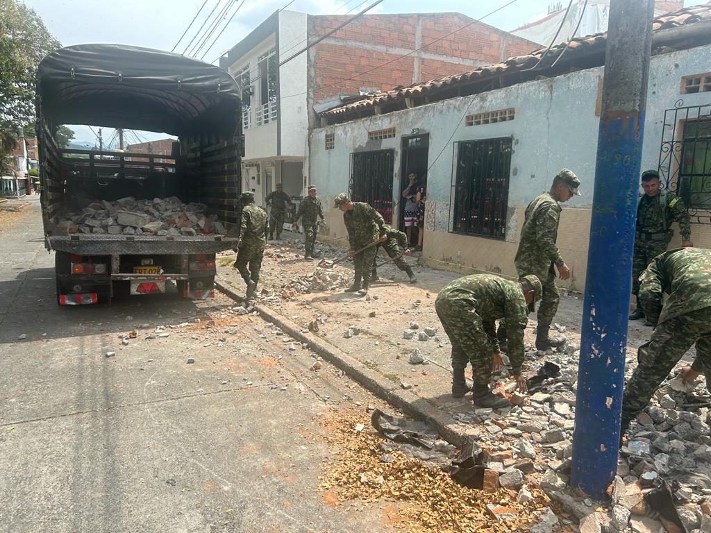 Soldados ayudando a la población a recoger escombros 